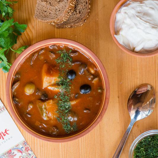 Wild mushrooms soup with salted cucumbers and olives e1634998606196